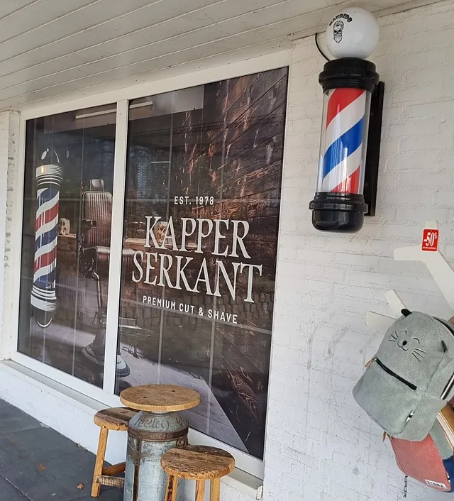 De gevel met de barberpaal en het raam met het logo