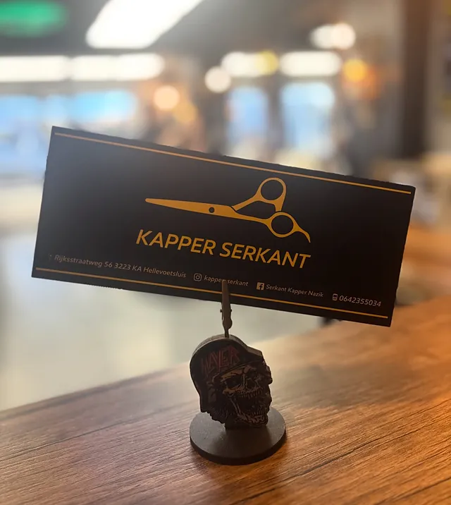 Het zwart met gouden kaartje van Kapper Serkant op de toonbank