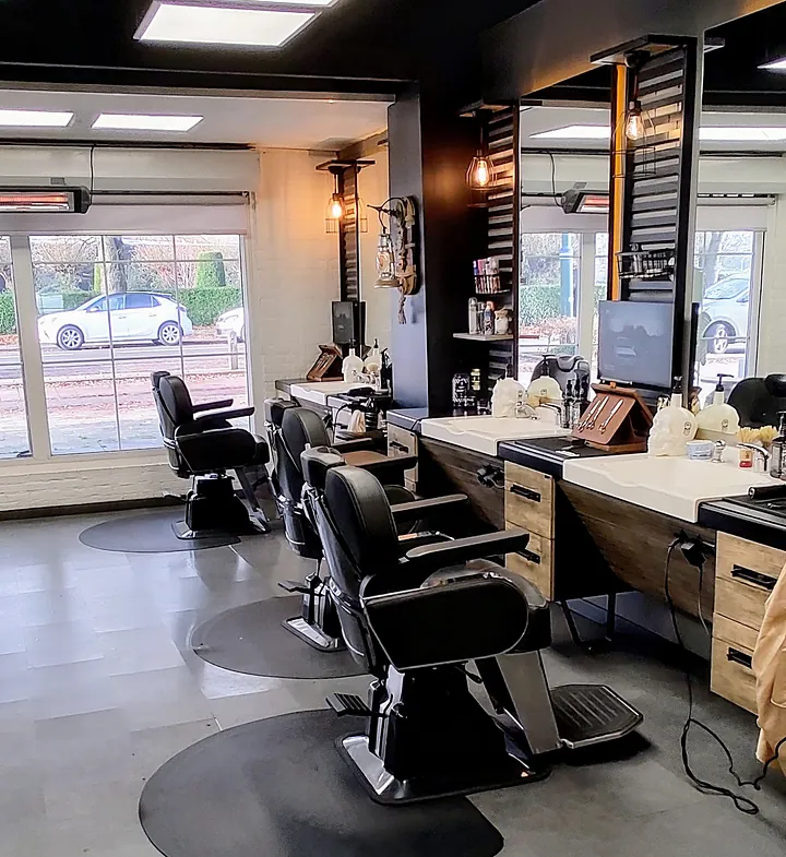 Zwarte barberstoelen voor de houten werkbanken